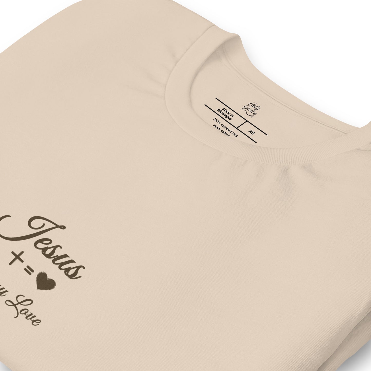 Close-up detail of cross design on Pure Love beige tee — Holy Grace