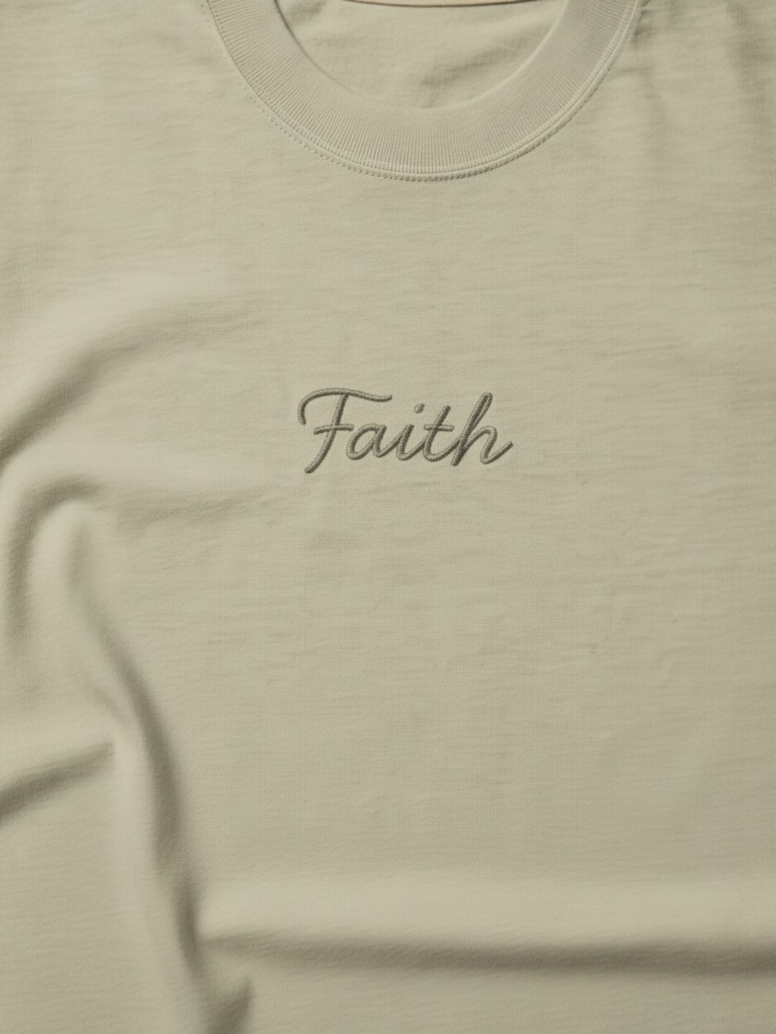 Beige t-shirt with 'Faith' embroidered on it