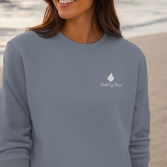 Person wearing a gray sweatshirt with a logo and text on a blurred background