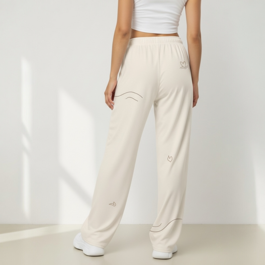 Person wearing beige sweatpants with subtle designs on a plain background