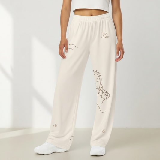 Person wearing cream-colored sweatpants with subtle designs on a plain background