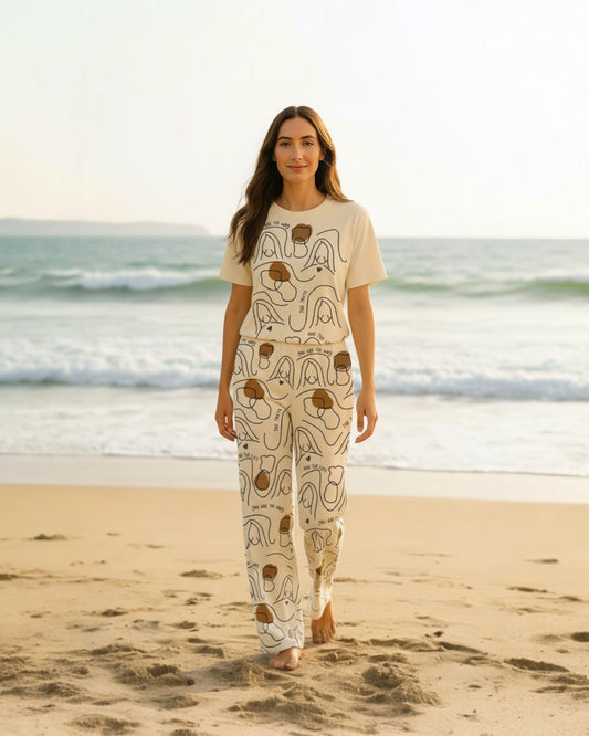 Woman walking on the beach wearing the unisex wide-leg pants with Jesus line-art design