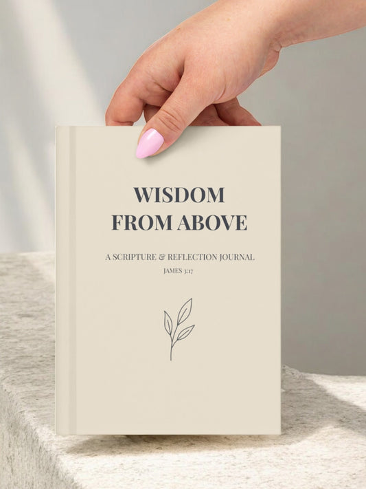  Hand holding the “Wisdom From Above” journal in a soft neutral setting.