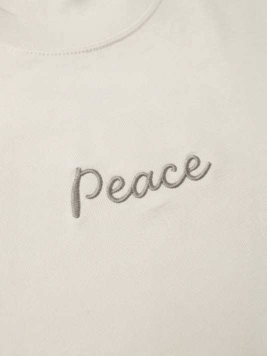 White shirt with 'Peace' embroidered on it