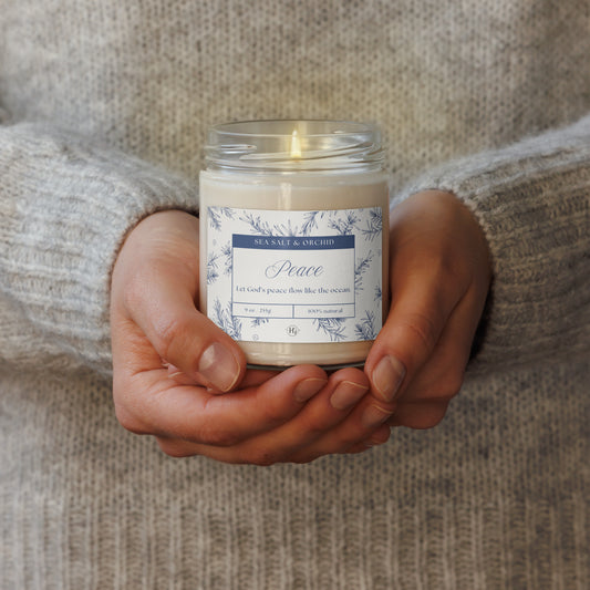 Woman holding Peace Candle – Sea Salt & Orchid, faith-inspired candle symbolizing calm and divine serenity by Holy Grace.