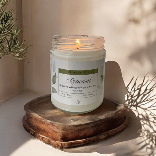 Renewal Candle – Clean Cotton glowing softly on a wooden base, fresh and uplifting soy candle by Holy Grace.