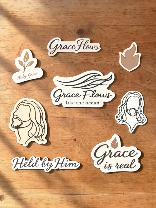 Set of white stickers with religious text and graphics on a wooden surface