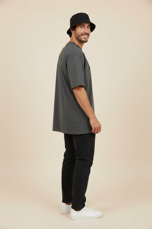 Side view of man wearing the God First oversized tee, minimalist Christian streetwear.